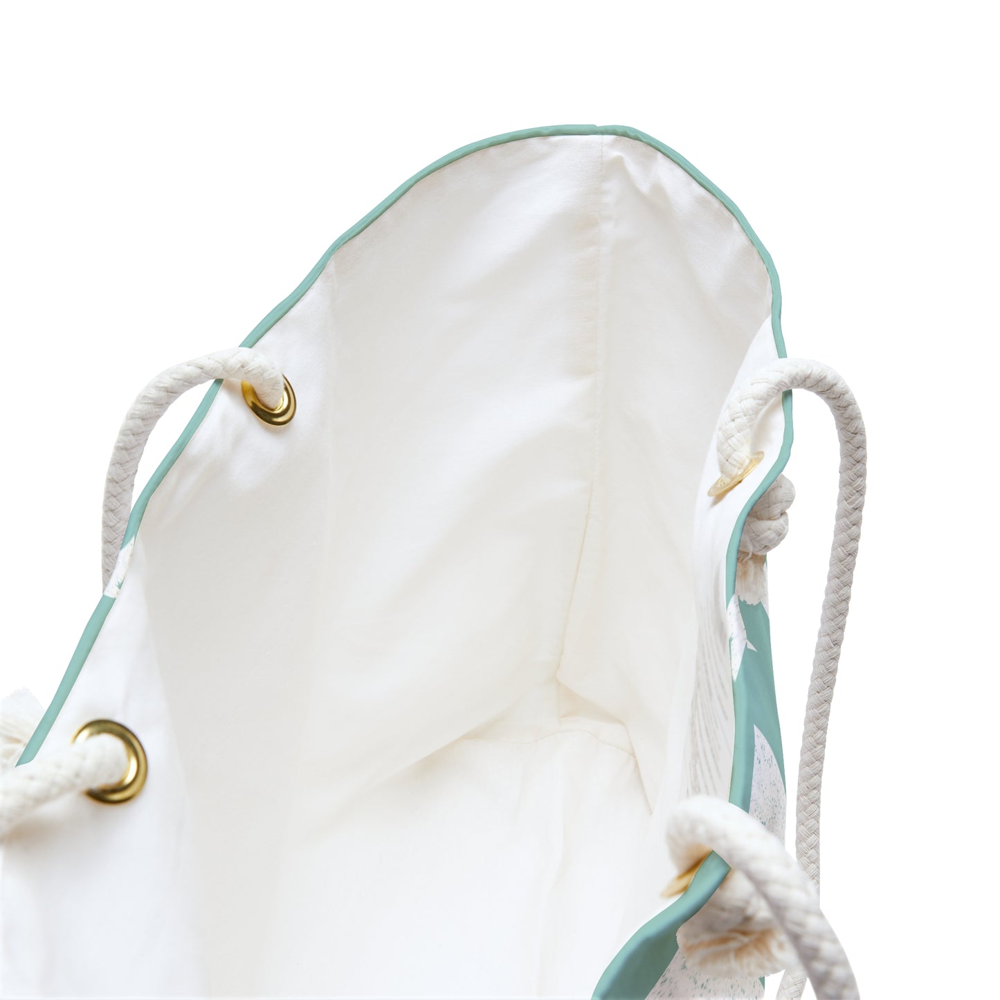 Close-up of the interior of a white drawstring bag with mint green piping, white rope handles, and gold-tone metal grommets on a white background.
