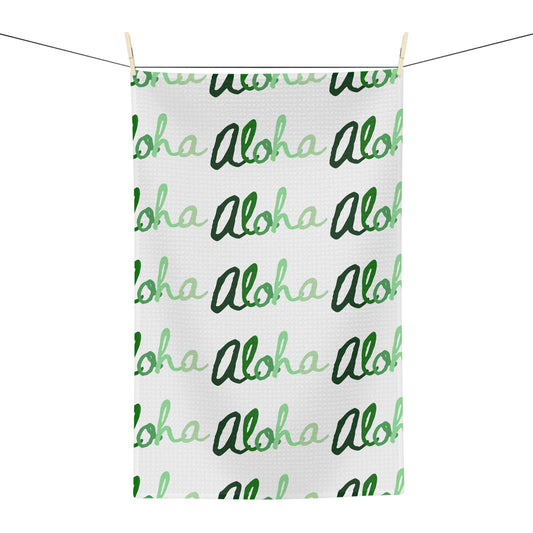 Green Aloha Hawaiʻi kitchen towel with repeating script design in light and dark green on white