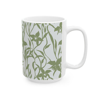 A white ceramic mug featuring an all-over sage green orchid floral pattern on a light gray background, shown against a plain white studio backdrop.