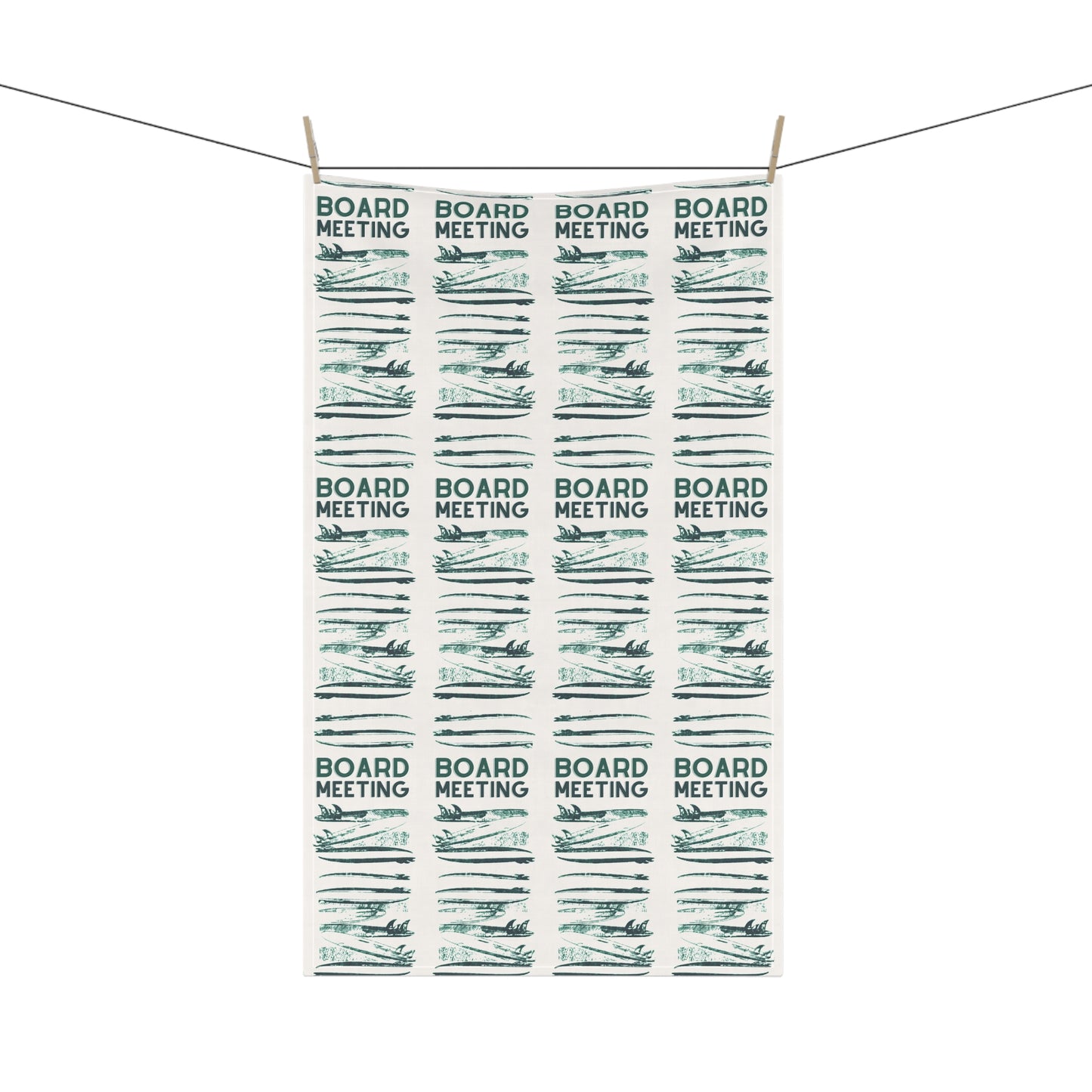 A rectangular white tea towel with a repeating pattern of 'BOARD MEETING' text and stylized board resolutions, hanging from two wooden clothespins on a string against a white background.