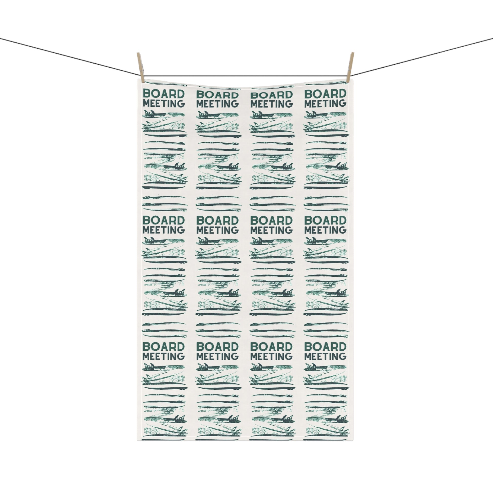 A rectangular white tea towel with a repeating pattern of 'BOARD MEETING' text and stylized board resolutions, hanging from two wooden clothespins on a string against a white background.