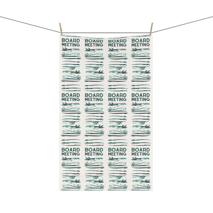 A rectangular white tea towel with a repeating pattern of 'BOARD MEETING' text and stylized board resolutions, hanging from two wooden clothespins on a string against a white background.
