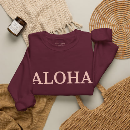 Maroon sweatshirt folded with text 'ALOHA' in light pink