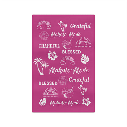 A raspberry pink kitchen towel featuring white tropical-themed illustrations and phrases including 'Grateful Mahalo Mode', 'THANKFUL', 'BLESSED', 'Grateful Mahalo Mode', and 'Mahalo Mode'.