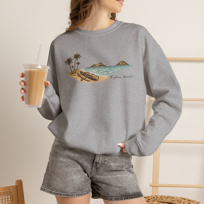 Woman standing holding an iced coffee wearing a Full color hand-drawn Kailua canoe and Mokulua Islands unisex sweatshirt on sport grey