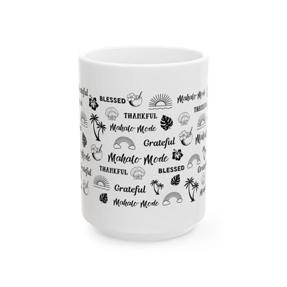 A white ceramic mug with a black tropical-themed pattern featuring the words 'Blessed', 'Grateful', and 'Mahalo Mode' alongside illustrations of palm trees, seashells, rainbows, and hibiscus flowers, shown on a plain white background.