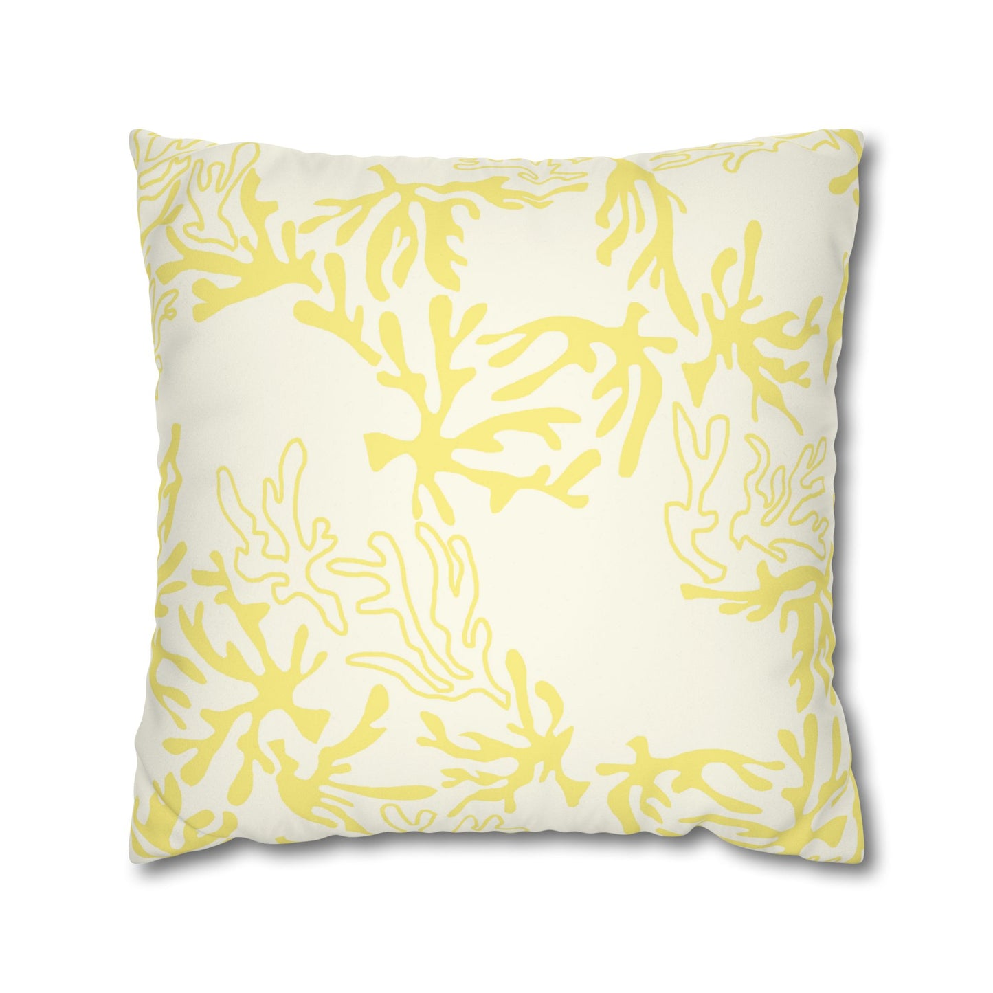 A square throw pillow featuring a yellow coral pattern on an off-white background, shown against a plain white studio backdrop.