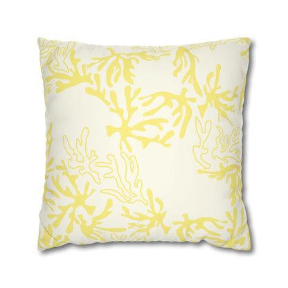 A square throw pillow featuring a yellow coral pattern on an off-white background, shown against a plain white studio backdrop.