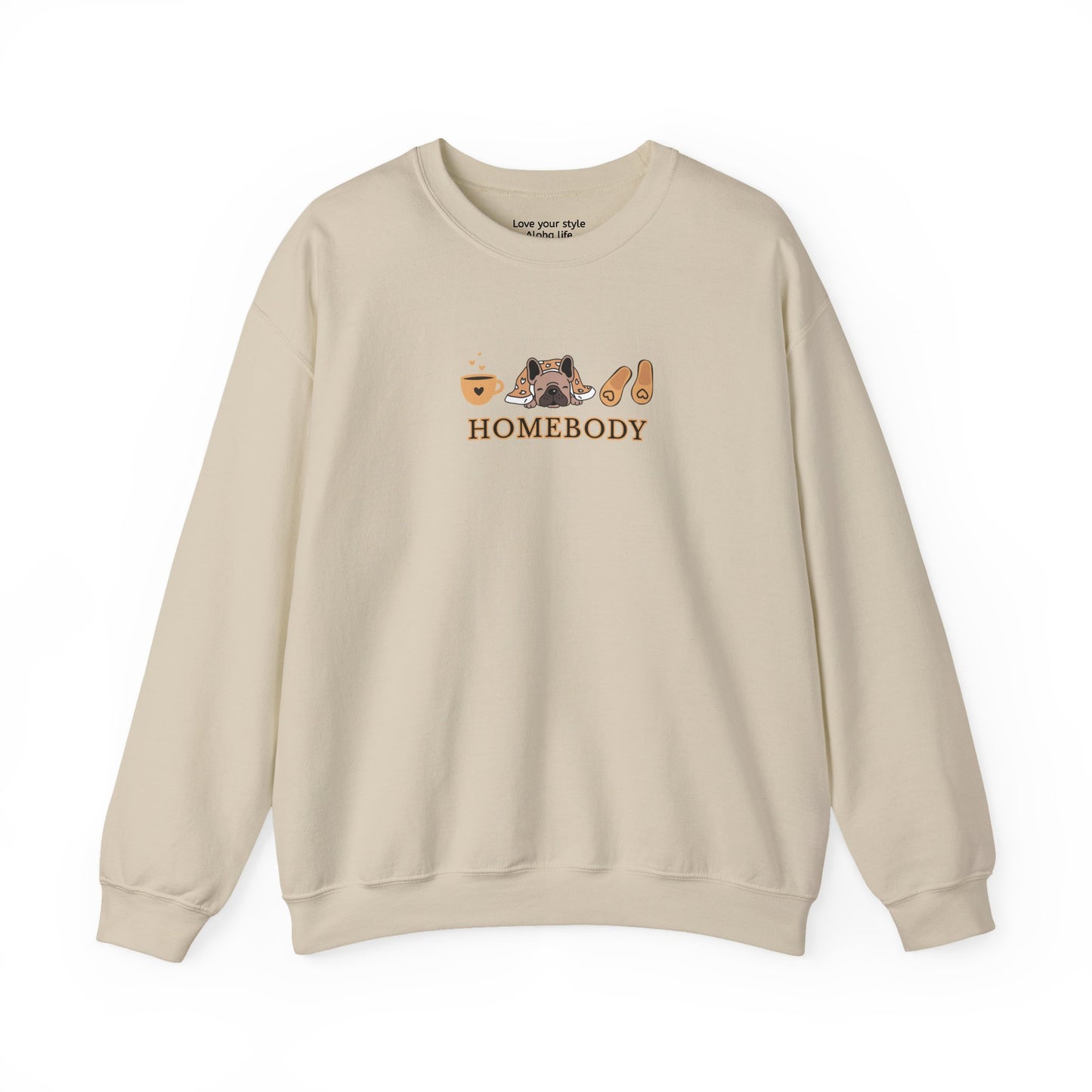 A beige crewneck sweatshirt featuring a central graphic of a dog under a blanket, house slippers, coffee cups and the word 'HOMEBODY' printed below it.