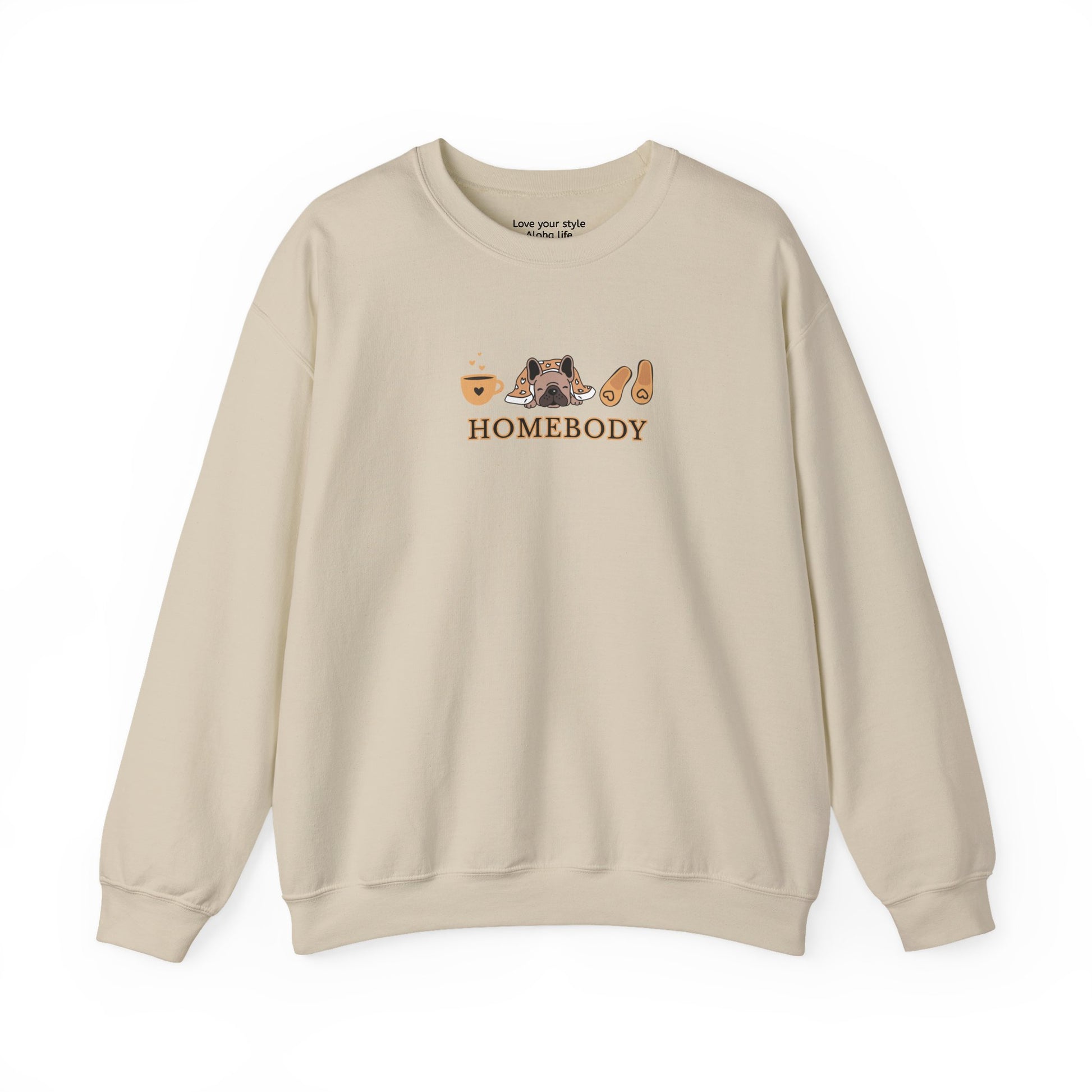 A beige crewneck sweatshirt featuring a central graphic of a dog under a blanket, house slippers, coffee cups and the word 'HOMEBODY' printed below it.