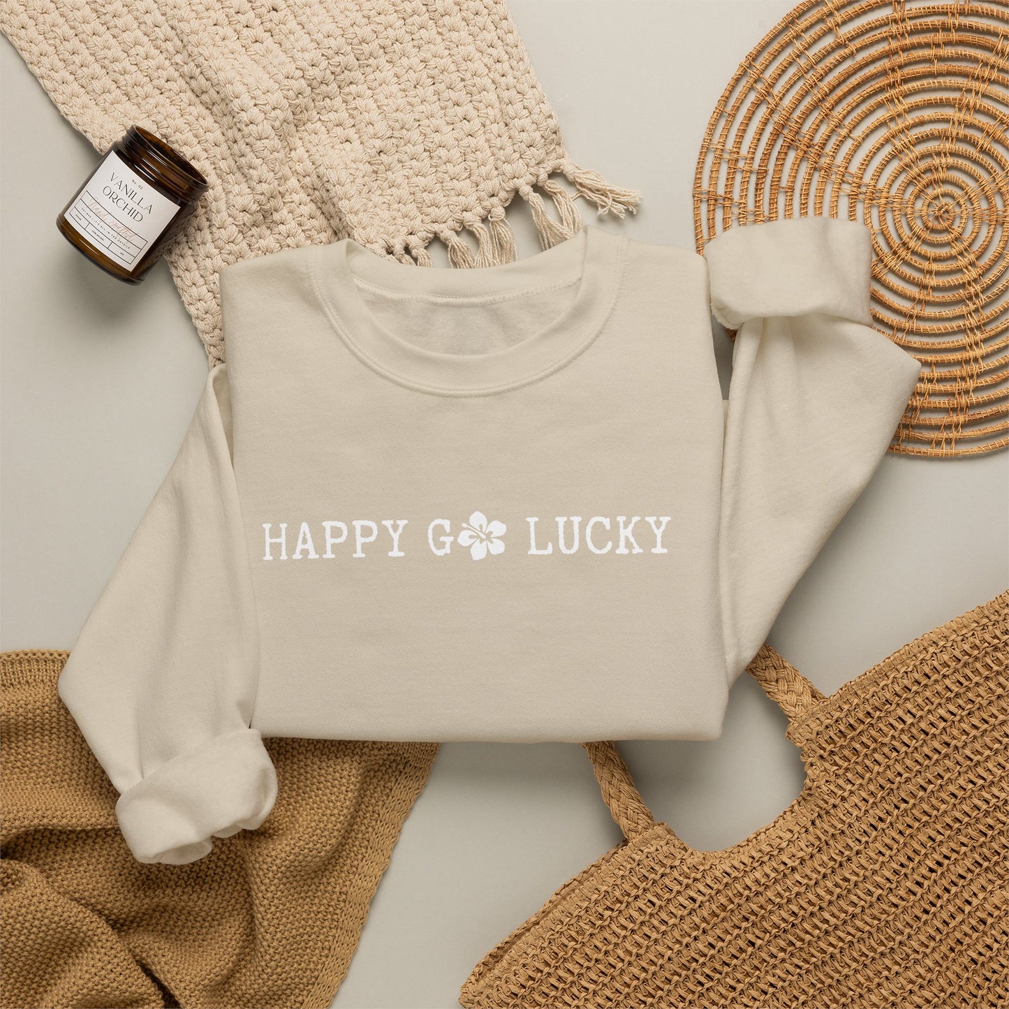 Beige sweatshirt with HAPPY GO LUCKY text on a textured surface