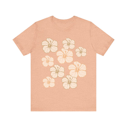 Soft peach Hibiscus All Over Graphic Tee featuring scattered tropical hibiscus flowers on a soft unisex tee inspired by island life in Hawaii.