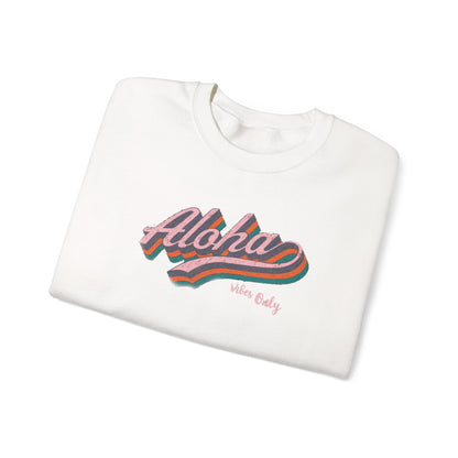 A folded white crewneck sweatshirt featuring a retro-style graphic on the front with the word 'Aloha' in pink script over wavy orange, teal, and green stripes, with 'Wear Only' printed in small pink text below.
