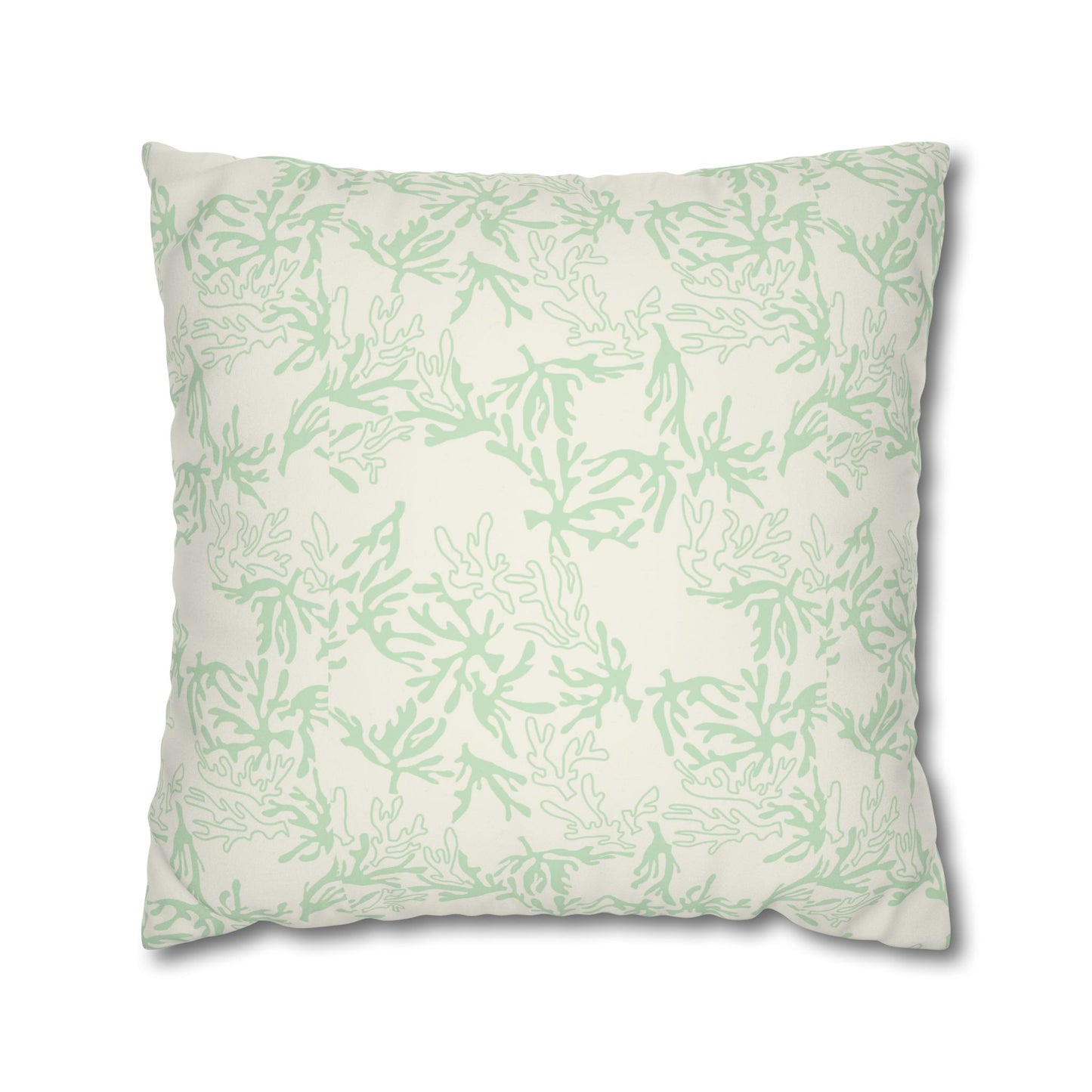 A square throw pillow featuring a light sage green coral branch pattern on an off-white background, shown against a plain white studio background.