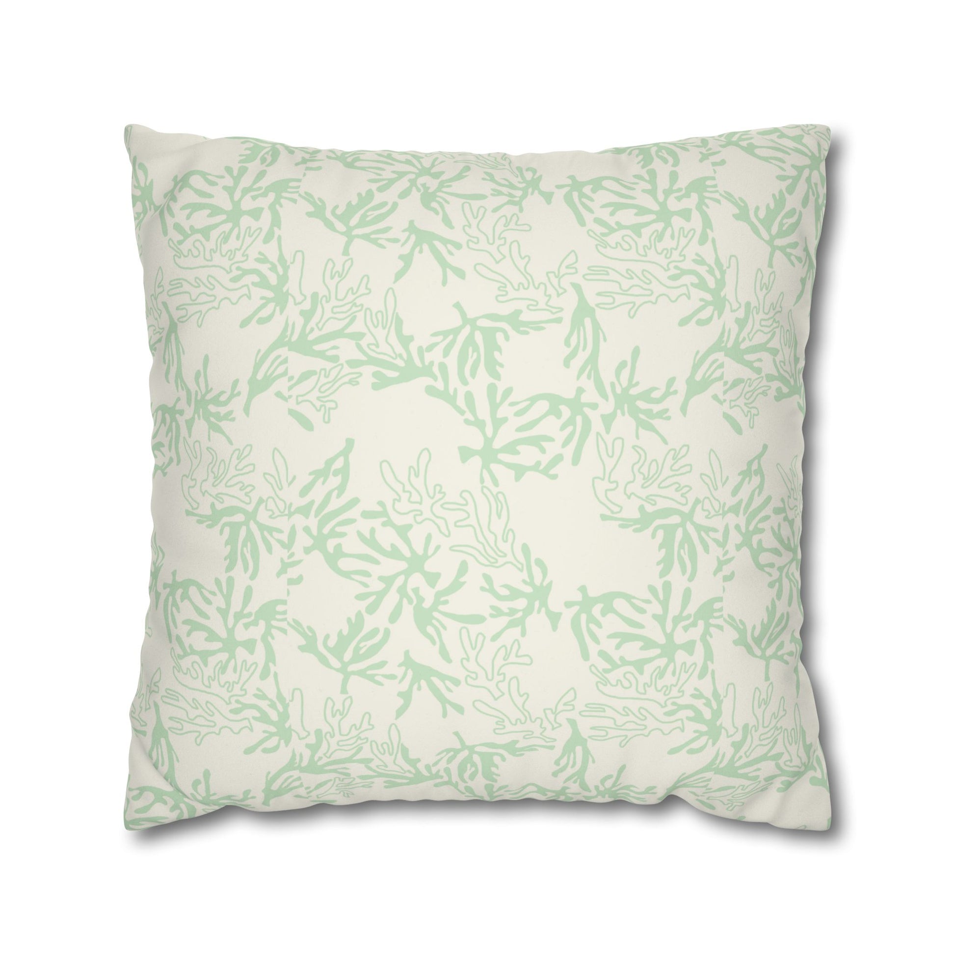 A square throw pillow featuring a light sage green coral branch pattern on an off-white background, shown against a plain white studio background.