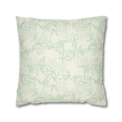A square throw pillow featuring a light sage green coral branch pattern on an off-white background, shown against a plain white studio background.