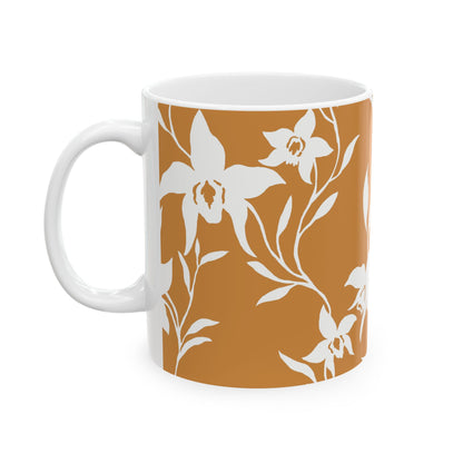 A white ceramic mug featuring a warm terracotta orange floral pattern of white orchids and leaves, shown against a plain white background.