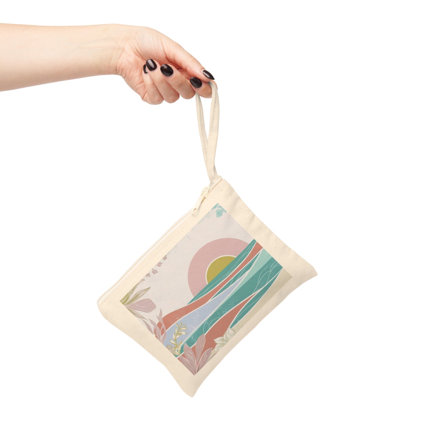 A hand with black nail polish holds a small cream canvas tote bag with a colorful abstract landscape print against a solid white background.