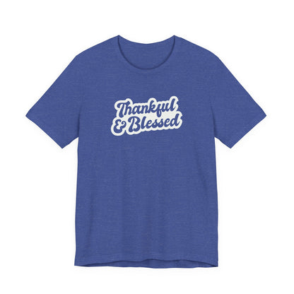 A heather blue short-sleeve t-shirt with a white graphic text print reading 'Thankful & Blessed' on the chest, displayed against a solid white background.