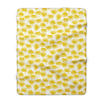 A rectangular throw fleece blanket, featuring a repeating pattern of yellow palm fronds on a white background.