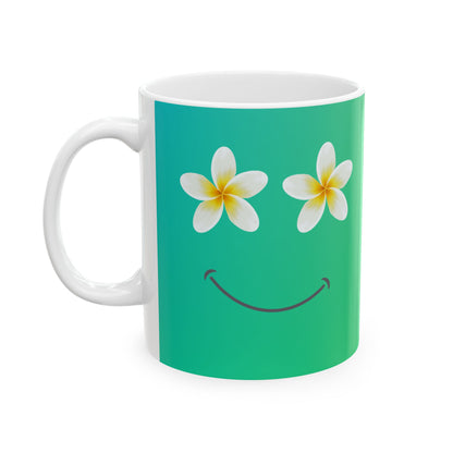 A white ceramic mug featuring a printed design of two white plumeria flowers with yellow centers as eyes and a simple black smile on a vibrant green gradient background.