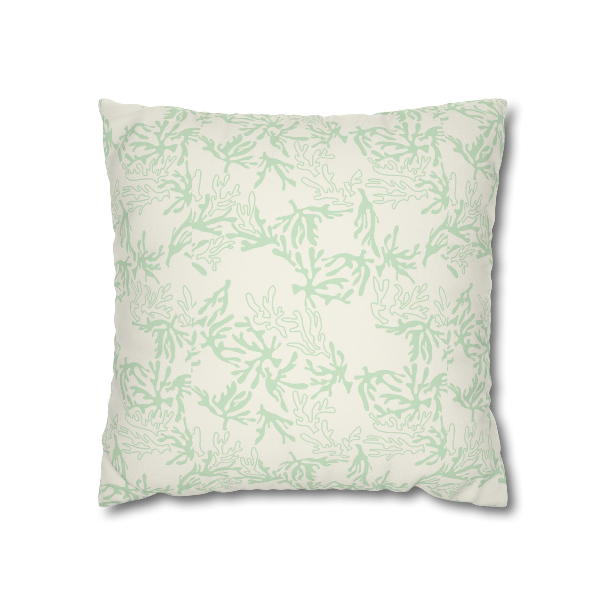 A square decorative throw pillow featuring a light sage green coral pattern on an off-white background, shown against a plain white studio backdrop.