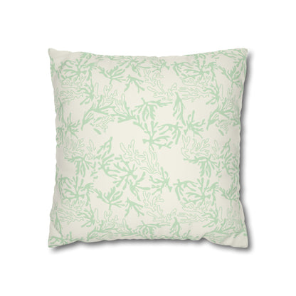 A square decorative throw pillow featuring a light sage green coral pattern on an off-white background, shown against a plain white studio backdrop.
