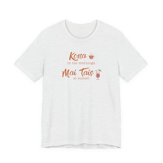 An ash short-sleeve crewneck t-shirt with a coral orange graphic on the chest that reads 'Kona in the mornings Mai Tais at sunset' with small coffee and cocktail illustrations.