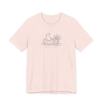 Pink t-shirt with a graphic design ʻKoa Dog on Pineapple Floatieʻ on a white background