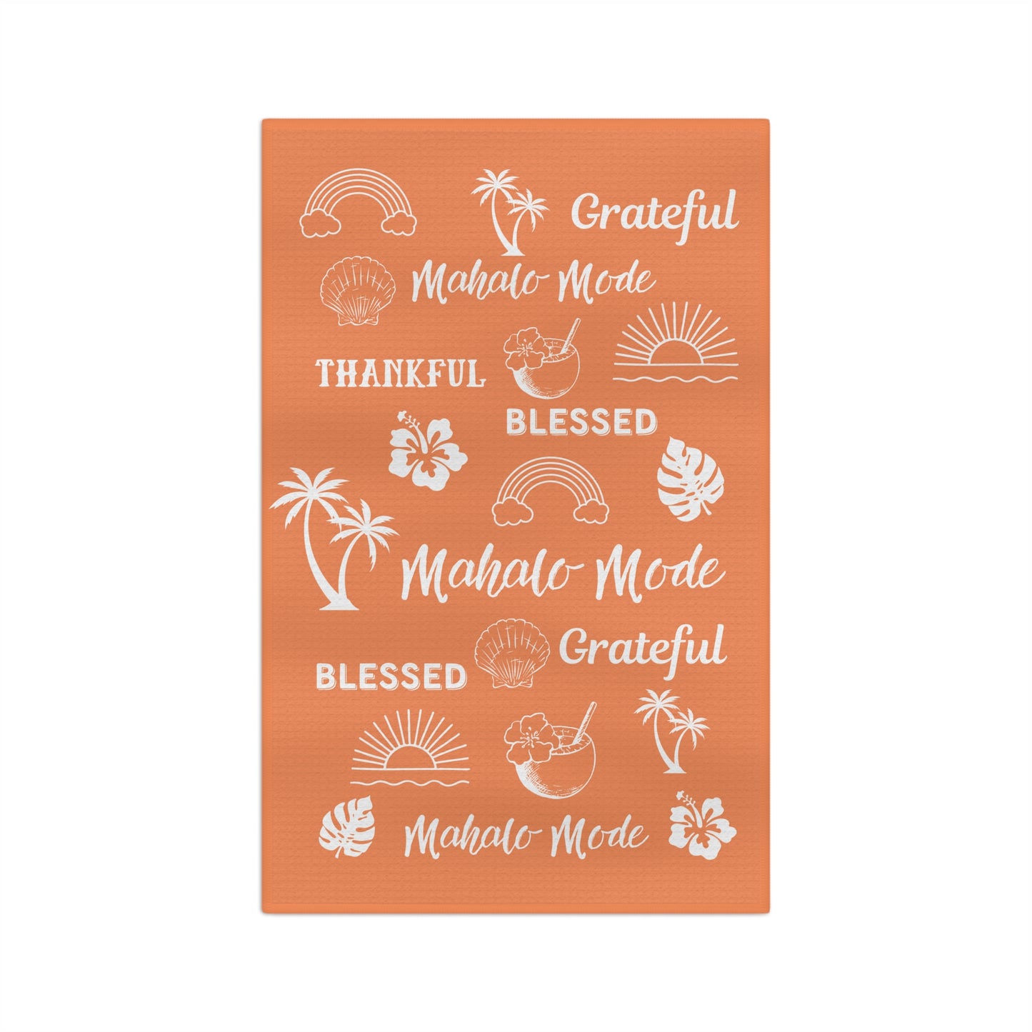 An orange kitchen towel featuring white tropical-themed illustrations and phrases including rainbows, palm trees, hibiscus flowers, seashells, and the words 'Grateful', 'Blessed', and 'Mahalo Mode'.