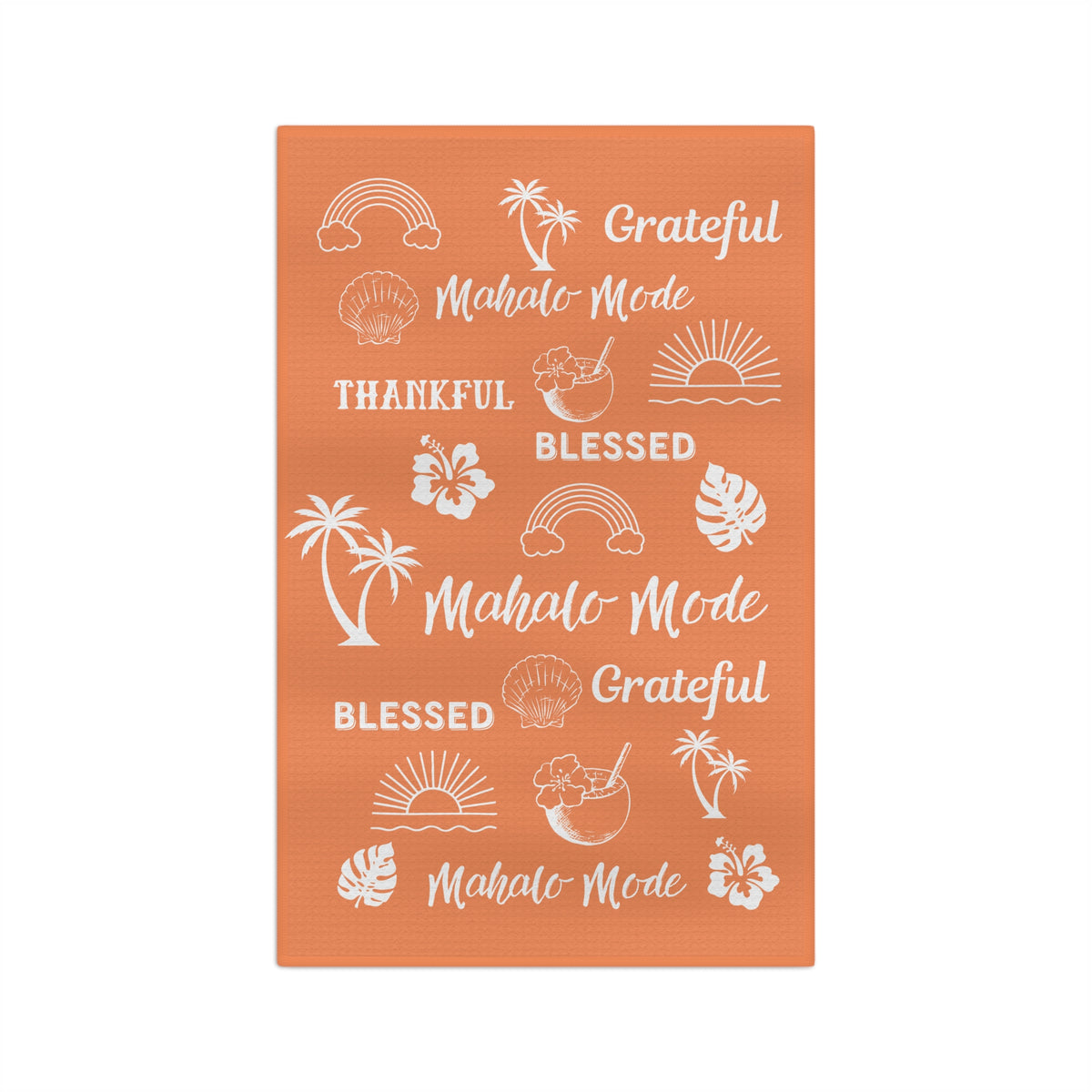 An orange kitchen towel featuring white tropical-themed illustrations and phrases including rainbows, palm trees, hibiscus flowers, seashells, and the words 'Grateful', 'Blessed', and 'Mahalo Mode'.