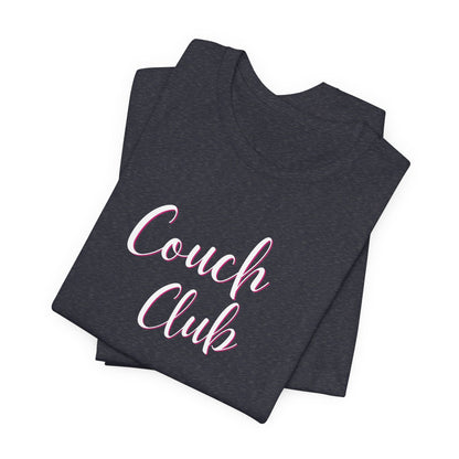 A folded dark heather gray t-shirt with 'Couch Club' printed in white script with a pink outline, displayed on a clean white background.