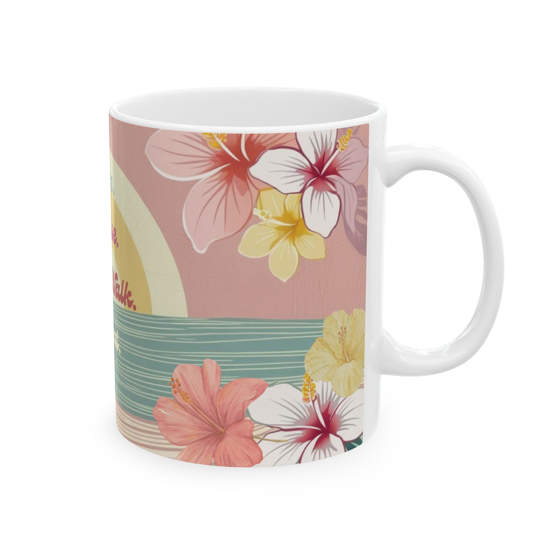 A white ceramic mug featuring a tropical floral print with pink, white, and yellow hibiscus flowers, a teal wave design, and a pale yellow sun on a dusty pink background.