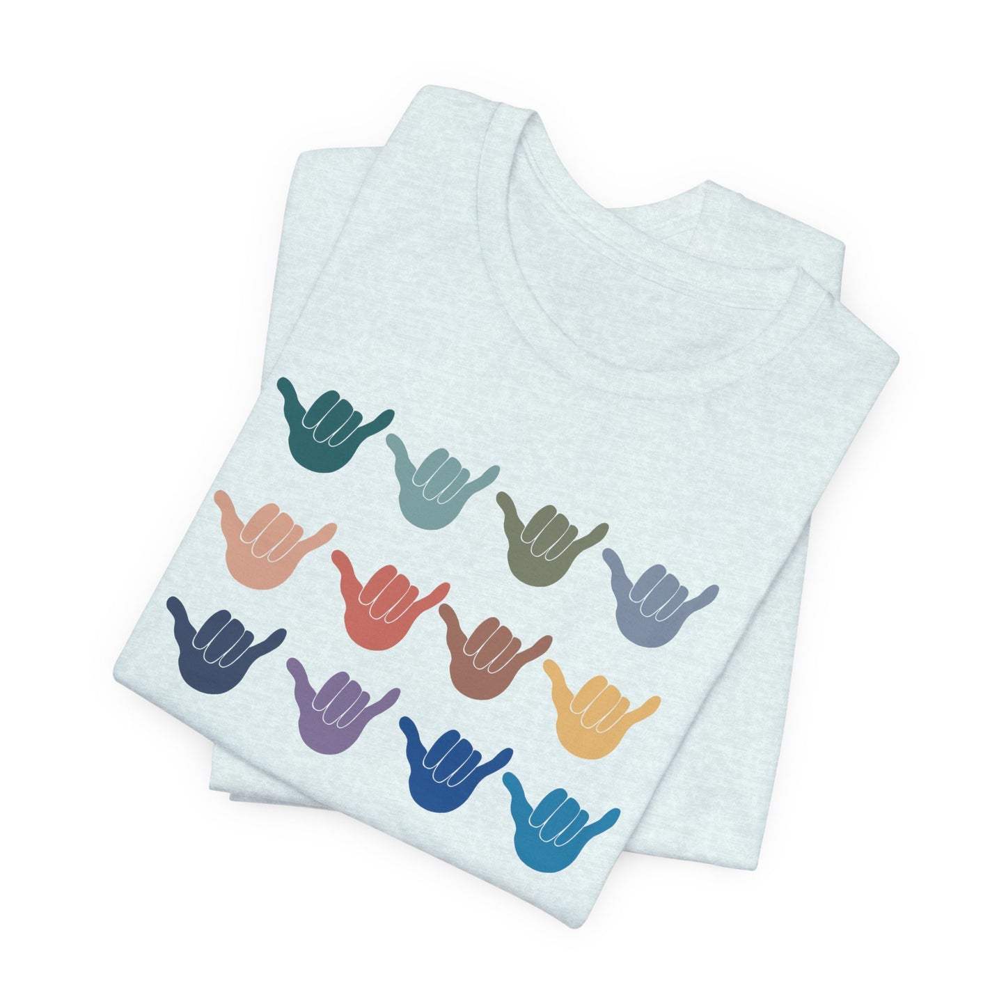 A folded light blue t-shirt featuring a grid of colorful shaka hand signs on the front, displayed on a clean white background.