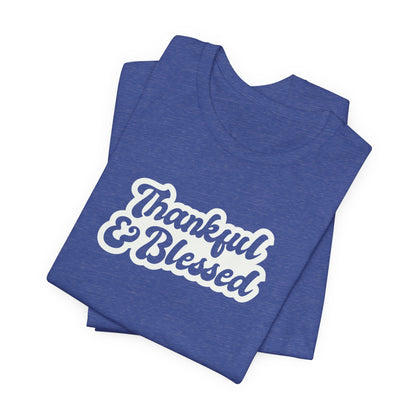 A folded heather blue t-shirt with 'Thankful & Blessed' printed in white script across the chest, shown on a plain white background.