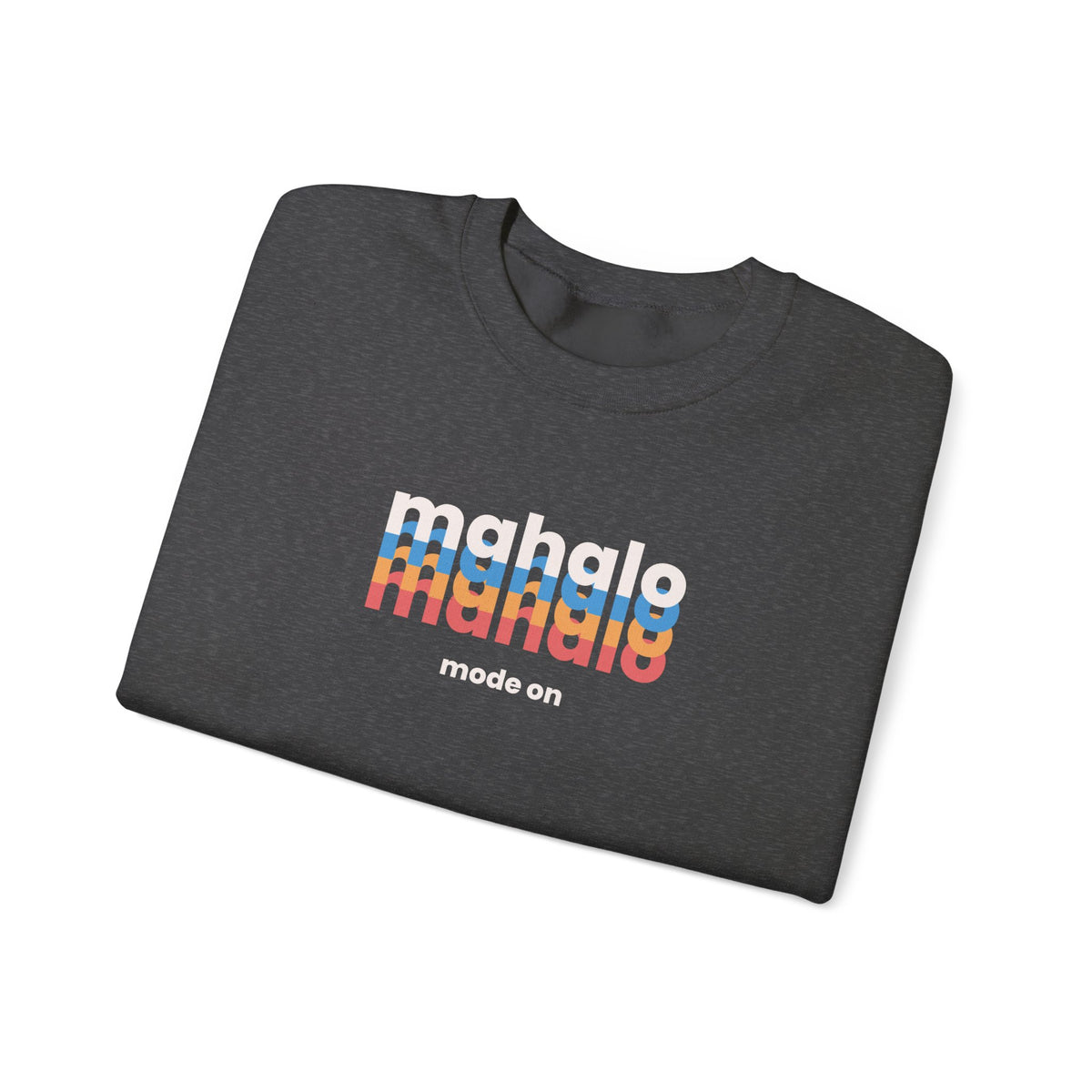 A dark heather gray folded t-shirt with a colorful retro-style 'mahalo mode on' graphic printed on the chest, displayed on a clean white background.