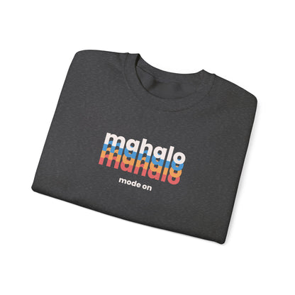 A dark heather gray folded t-shirt with a colorful retro-style 'mahalo mode on' graphic printed on the chest, displayed on a clean white background.