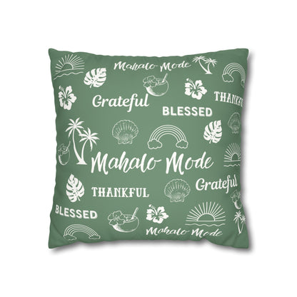 A square throw pillow in sage green with a white tropical-themed print featuring palm trees, hibiscus flowers, seashells, rainbows, and words like 'Mahalo Mode', 'Grateful', and 'Blessed'.