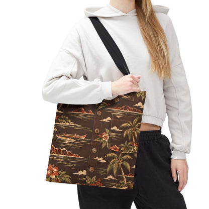 A woman wearing a white hoodie and black sweatpants carries a brown button-up shirt-style tote bag with a tropical print featuring palm trees, canoes, mountains, and flowers. The bag has a black shoulder strap and is shown against a plain white background.