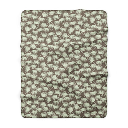 A rectangular throw blanket with a repeating palm frond pattern in sage green on a taupe brown background, shown flat against a white background.