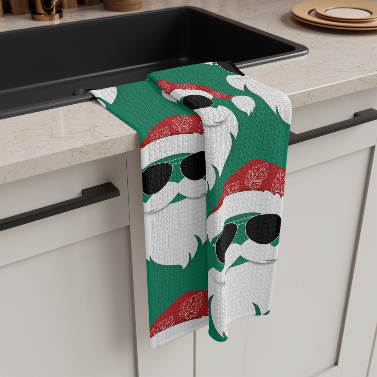Cool Santa Aloha Kalikimaka kitchen towel with sunglasses Santa, tropical greenery and Christmas ornaments design hanging off kitchen sink