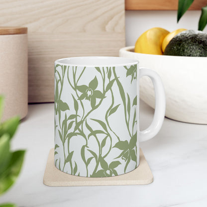 Orchid Sage coffee mug with tropical orchid print by Global Village Kailua sitting on a coaster on a kitchen counter with fruit bowl.