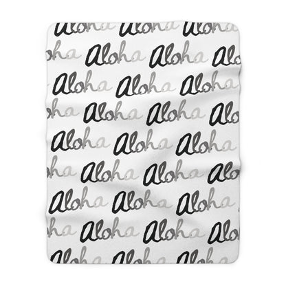 Aloha grayscale sherpa fleece blanket with a repeating black, white and gray island-inspired design.