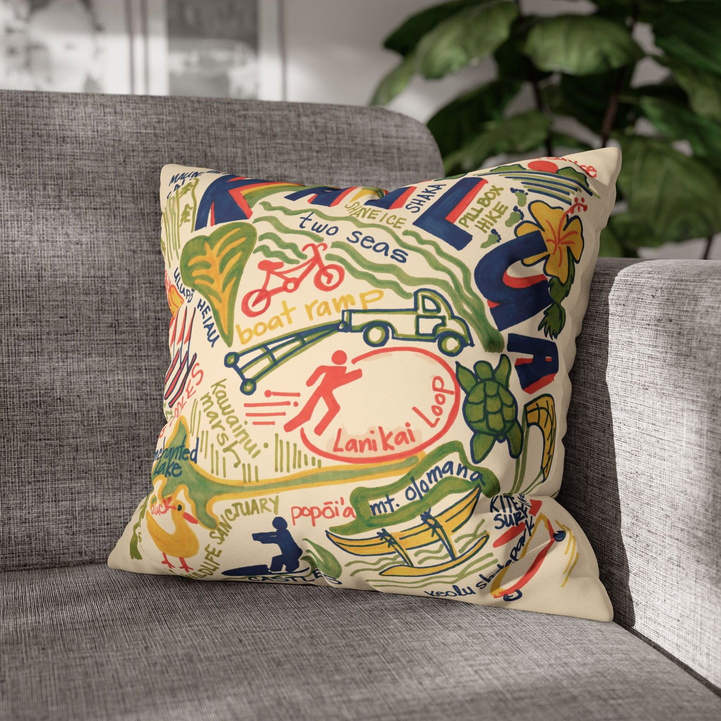 Decorative faux suede throw pillow cover featuring an original hand-drawn illustration of Kailua, Hawaii landmarks, beaches, surfing, paddling, turtles, and island icons on a grey couch.