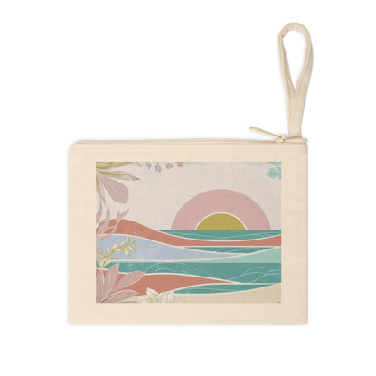 A canvas zippered pouch with a cream-colored fabric body and a matching wrist loop. The front features a square graphic print of a stylized landscape with a pink and yellow sunset over teal water and pinkish-orange dunes, framed by botanical illustrations.