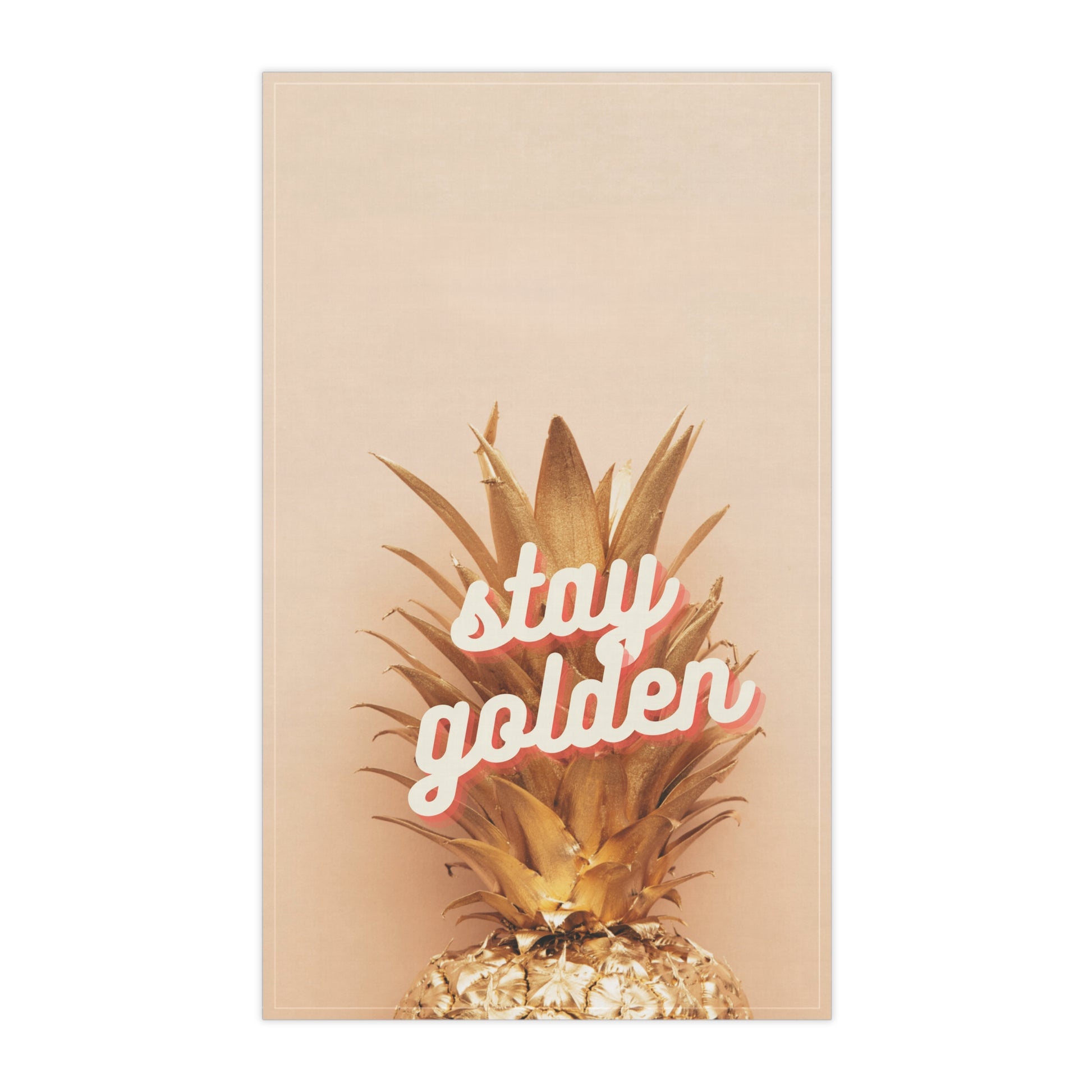 A tea towel featuring a golden pineapple on a warm beige background with the phrase 'stay golden' in white script outlined in pink, shown against a plain white backdrop.