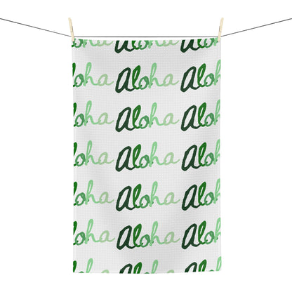 Green Aloha Hawaiʻi kitchen towel with repeating script design in light and dark green on white