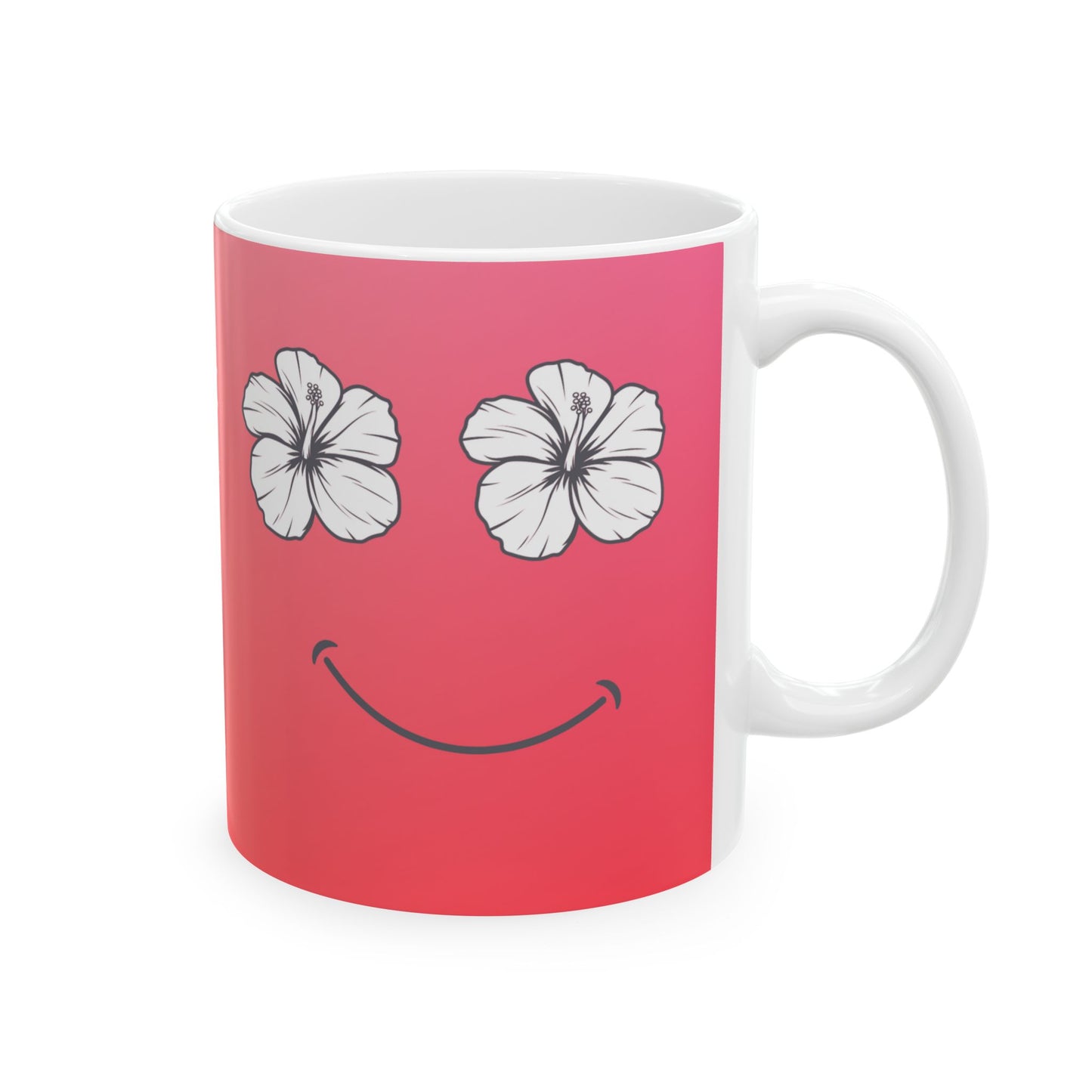 A white ceramic mug featuring a pink printed wrap design with two white hibiscus flowers for eyes and a simple black smiley curve.