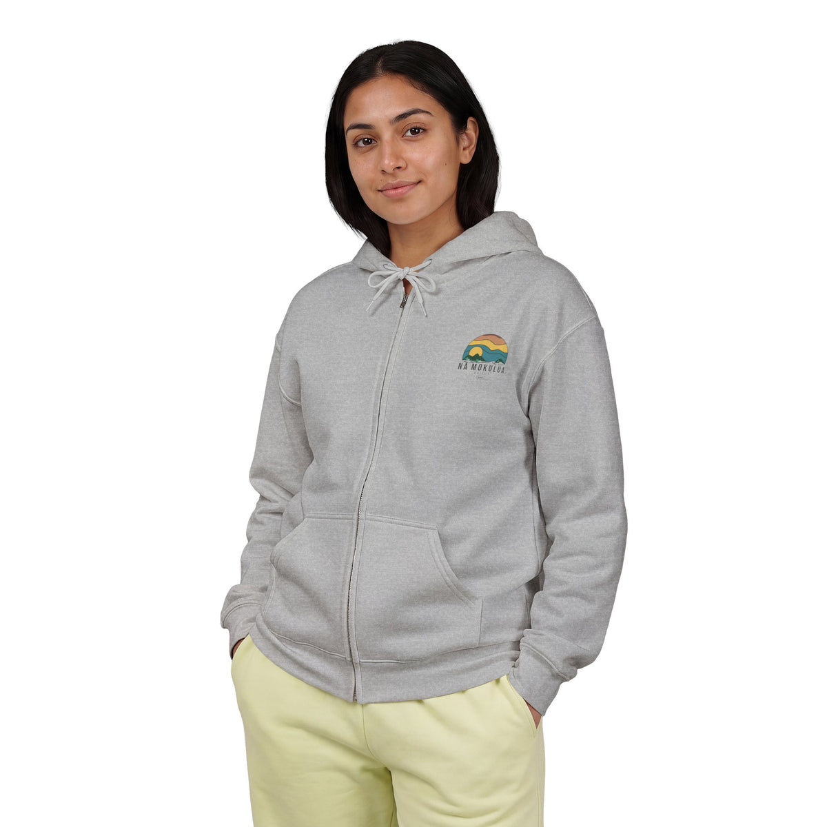 woman wearing Nā Mokulua Kailua grey zip hoodie with small retro island sunset graphic on left chest