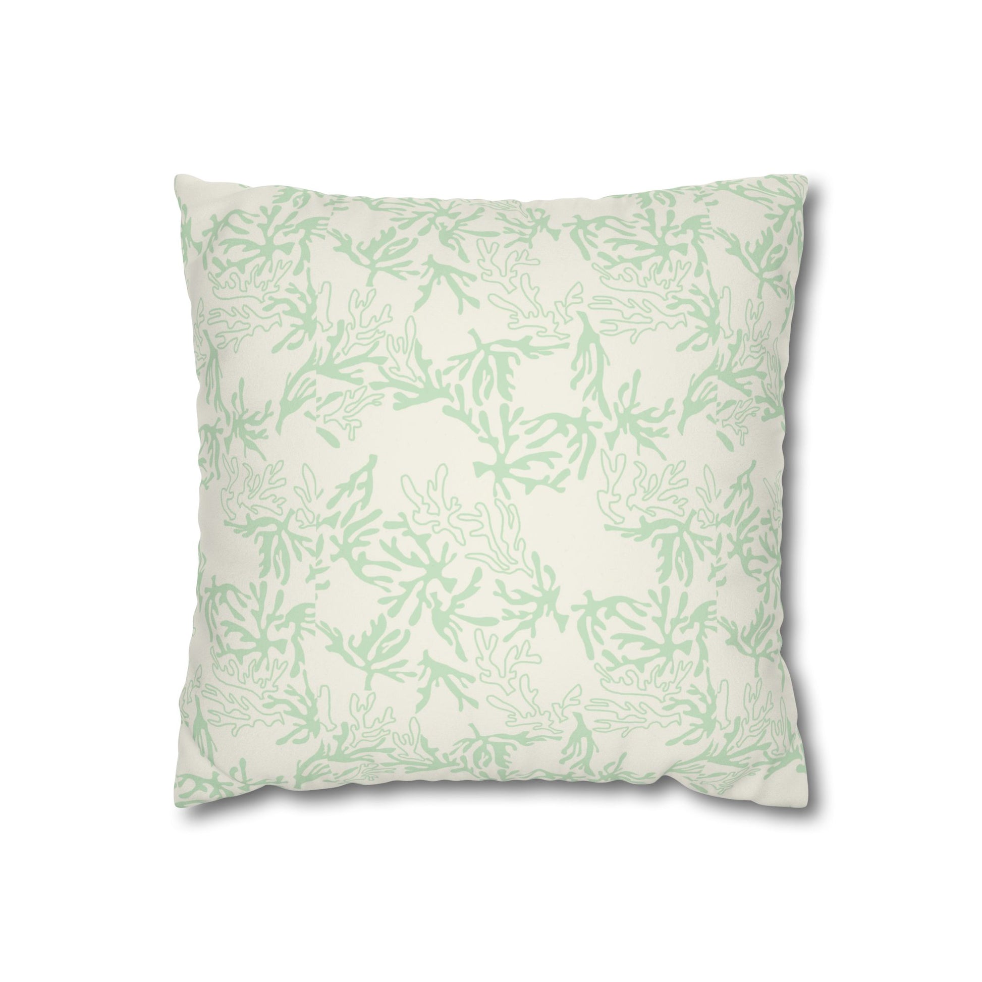 A square throw pillow with a light sage green coral pattern on an off-white background